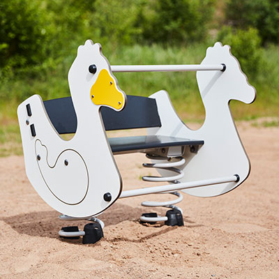 A springer toy at a playground shaped like a white duck with yellow beak.